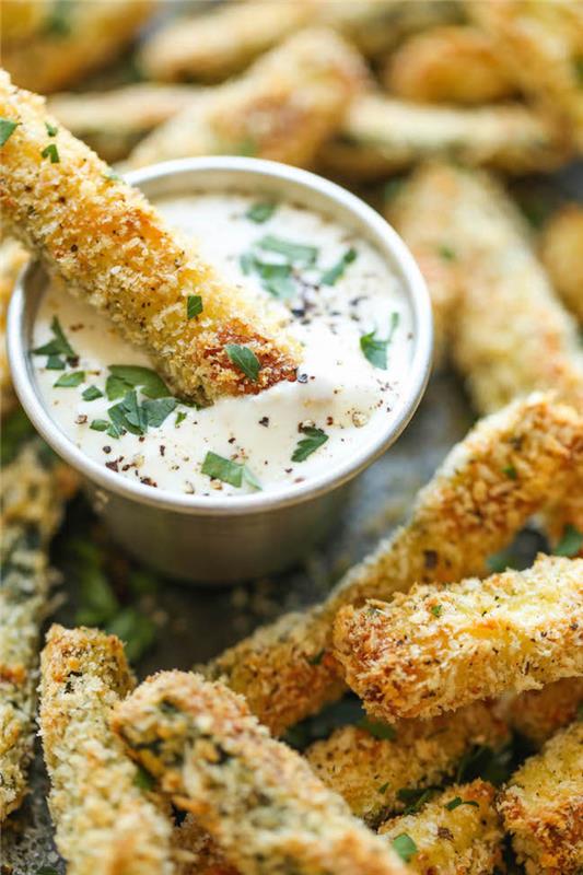 Aperitivo vegetariano e un'idea con dei bastoncini di zucchine con salsa bianca