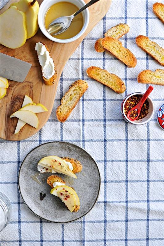 Aperitivo vegano con delle bruschette di pane con pere e formaggio ricotta spalmabile