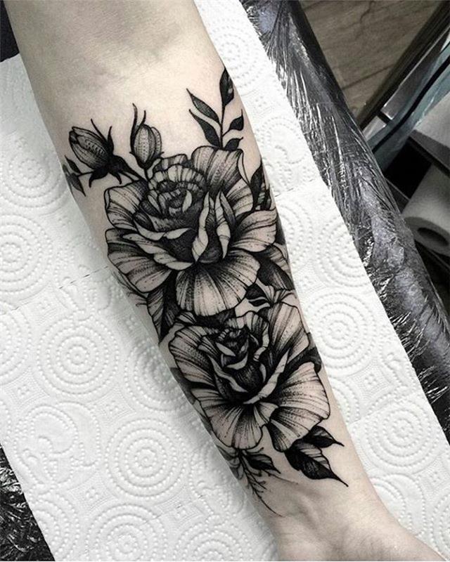 Tatuiruotė senosios mokyklos braccio con il disegno floreale sull'avambraccio di una donna