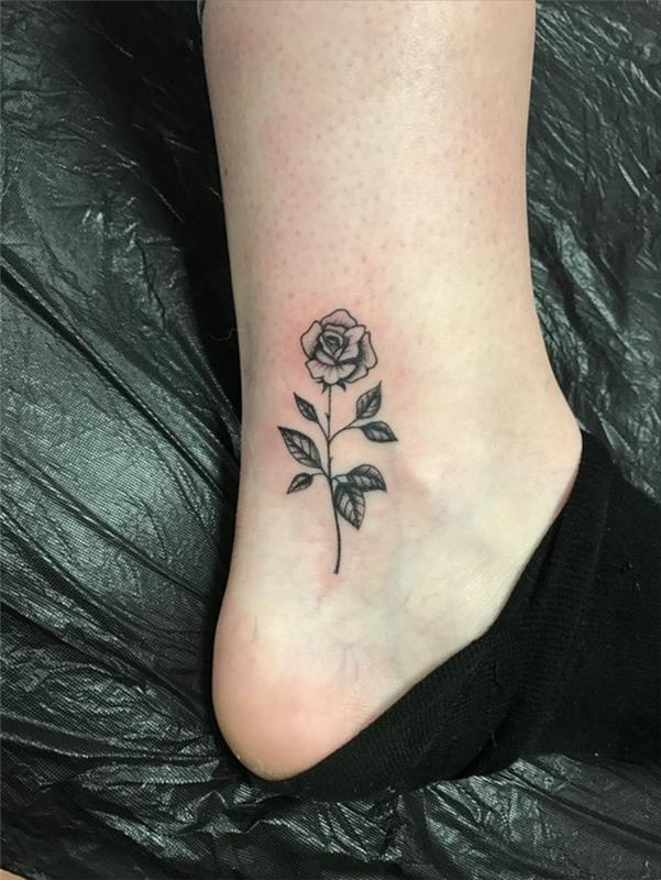gėlių tatuiruotė, maža rožė tatuiruota ant kulkšnies, žydėjusi rožė juodu rašalu
