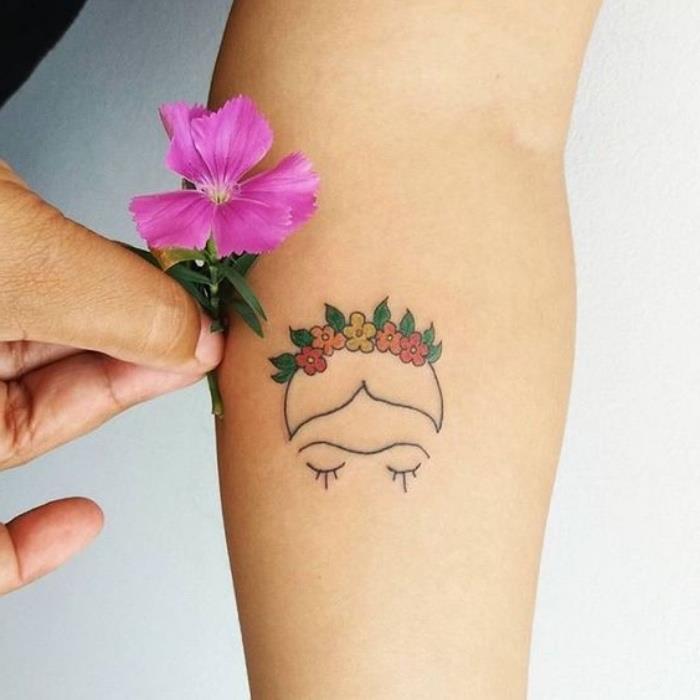 moteris, laikanti gėlę, veido ir gėlių karūnos dilbio tatuiruotę, mažą tatuiruotę, baltas fonas