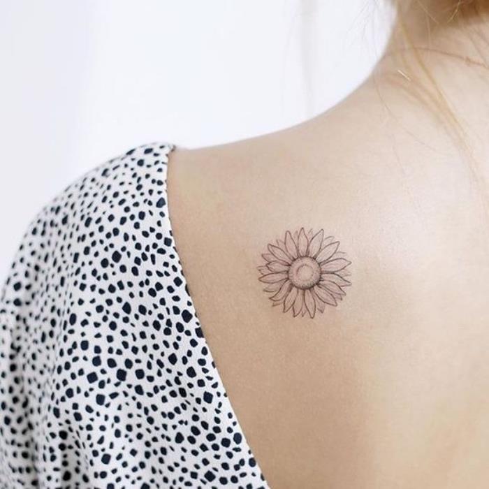 moteris dėvi juodai baltą viršutinę dalį, saulėgrąžų pečių tatuiruotę, mažas prasmingas tatuiruotes