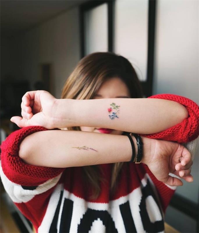 spalvingos gėlės dilbio tatuiruotės, ant abiejų rankų, mažos tatuiruotės su prasme, moteris dėvi raudoną megztinį