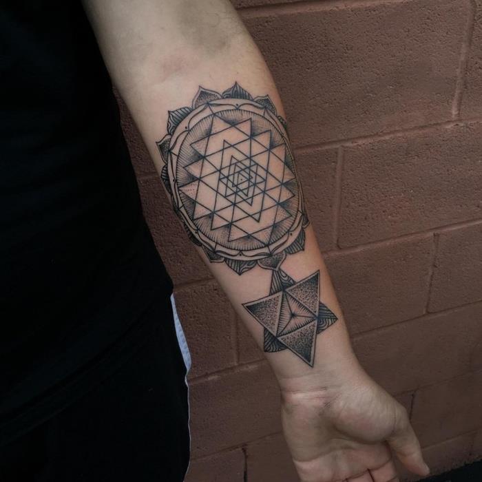 geometrijski trikotniki in krogi, tetovaža podlakti, ravnotežna tetovaža, opečna stena v ozadju