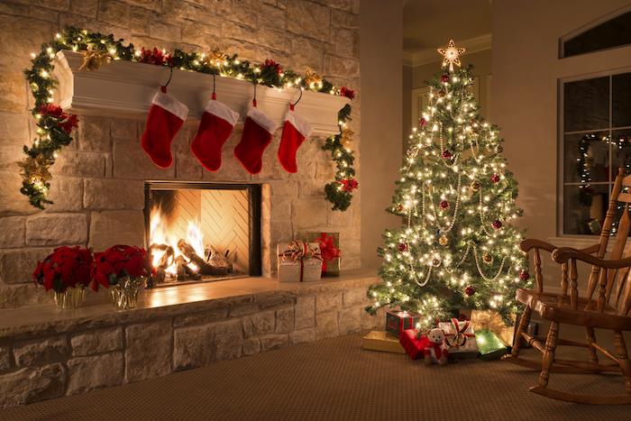 Kalėdinis maistas gyvenamajame kambaryje, papuoštas vakarėliui, kalėdiniai rutuliai ir šviesios girliandos, židinys, kalėdinė girlianda ir žvaigždės, kabančios kalėdinės kojinės