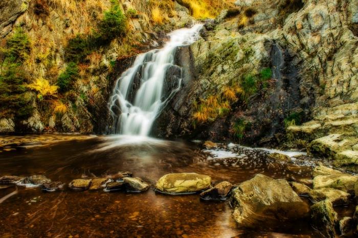 kristalno čista reka, slapovi, skalnate pečine in nizko rastje, ozadje za računalnik brezplačno