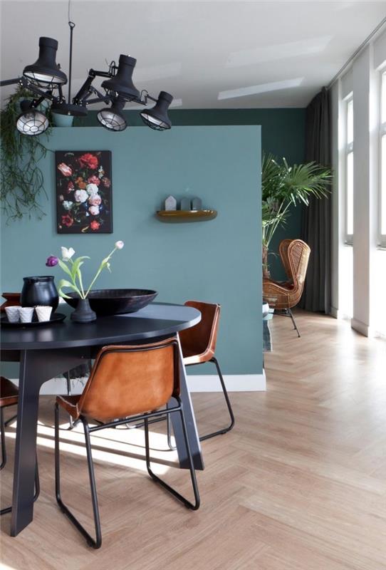 petrol mavisi boyanın farklı tonlarının kullanılması, oturma odası ve yemek odasının iki farklı alanını görsel olarak ayırmayı sağlar.
