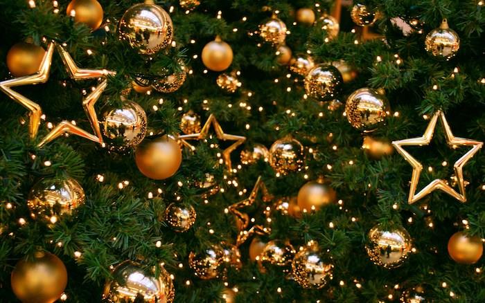 Kalėdų fonas Kalėdų eglutėje, papuoštoje auksiniais ornamentais, Kalėdų rutuliais ir žvaigždėmis aukso ir šviesios girliandos