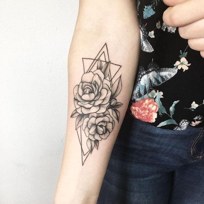 Il braccio di una donna tatuato con un fiore di loto e forme geometrik şekil