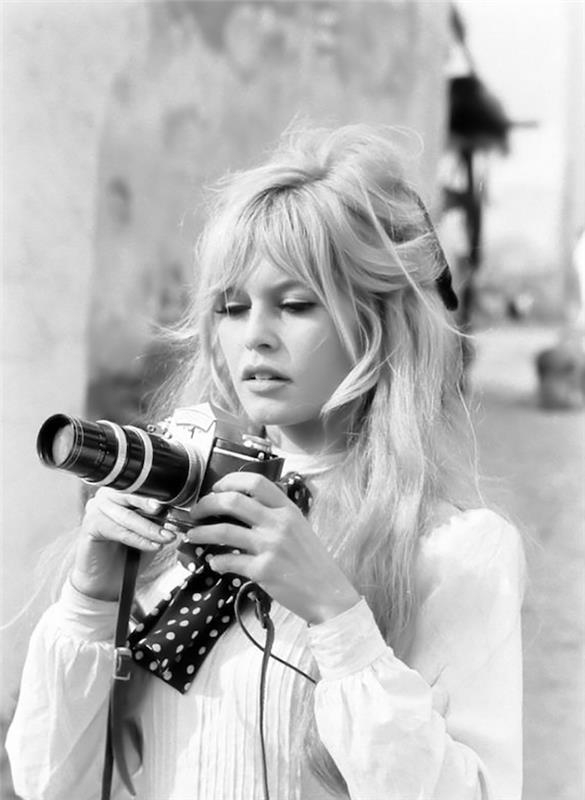 brigitte bardot elinde bir kamera fotoğrafı tutan siyah beyaz bir görüntü patlatıyor
