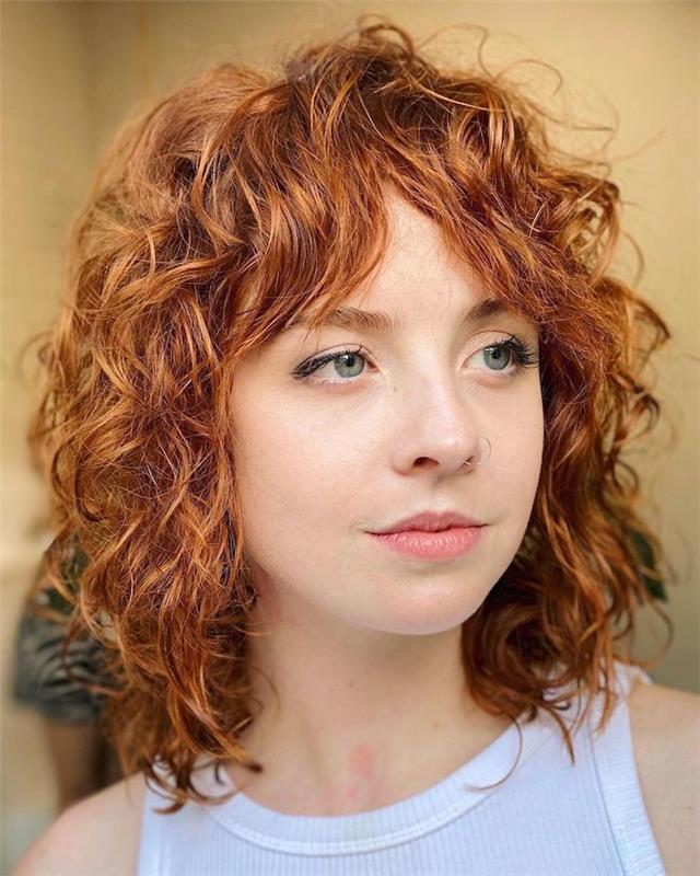 kıvırcık kızıl saçlı ve burun piercingli bir kadın