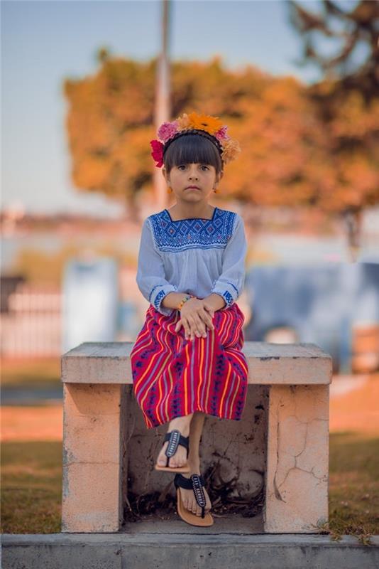 Nuotrauka, įkvėpta Frida Khalo stiliaus, meksikietiško sijono, gėlių vainiko ir žemos bandelės su kirpčiukais mergaitei, lengva šukuosenos pamoka