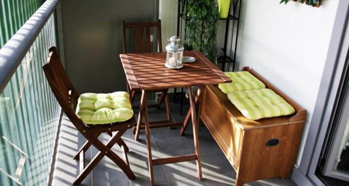 masa ve kanepeli iki ahşap sandalye, soluk yeşil çizgili minderler, veranda fikirleri, arka planda bitkilerle dolu raflar