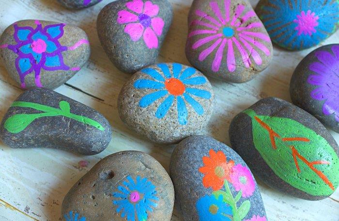 bir çocuğun birincil el aktivitesi örneği, çeşitli renklerde dekore edilmiş çiçek desenleriyle süslenmiş çakıl taşları