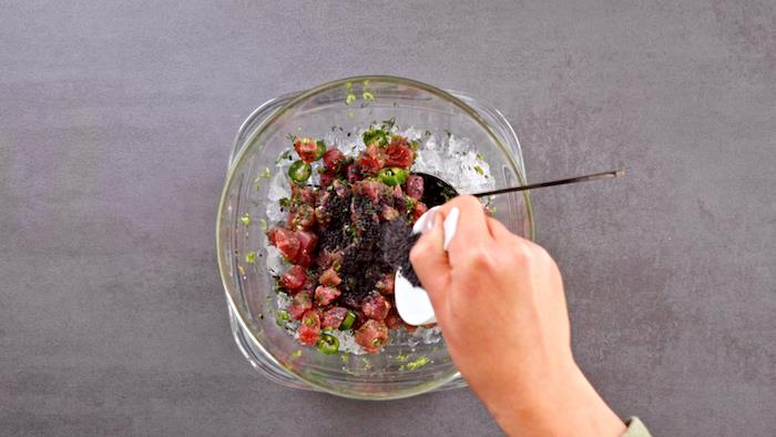 į kubeliais pjaustytą tuną, pagardintą šviežiomis žolelėmis, įpilkite juodųjų sezamų, receptą su avokadu ir žuvimi