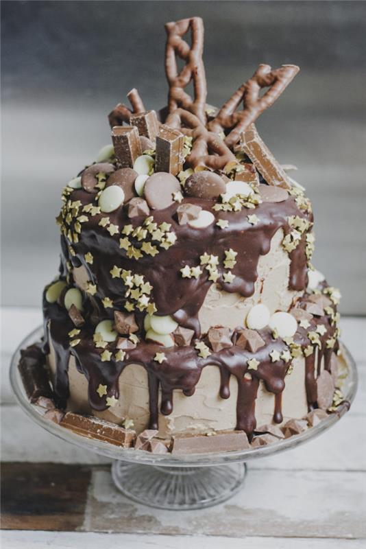 Drėgnas ir švelnus šokoladinis pyragas kietas dviejų pakopų gimtadienio tortas, papuoštas šokoladiniais saldainiais