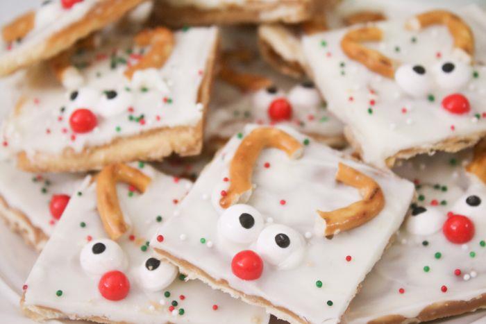 enostaven recept za božično torto navaden piškotek, prekrit z belo čokoladno karamelo, pereče oči z božičkovim vzorcem jelenov