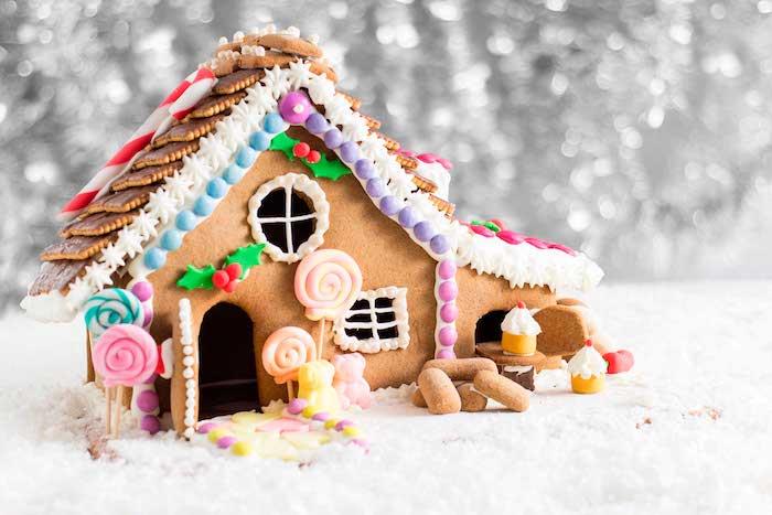 çikolatalı kurabiyeler, tatlı şekerler ve küçük tatlı figürinler ile güzelce dekore edilmiş zencefilli ev