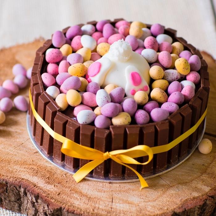 enostavna in hitra velikonočna torta s kit-kat palicami in pastelnimi čokoladnimi jajci, posebna velikonočna zajčja torta na lesenem hlodu