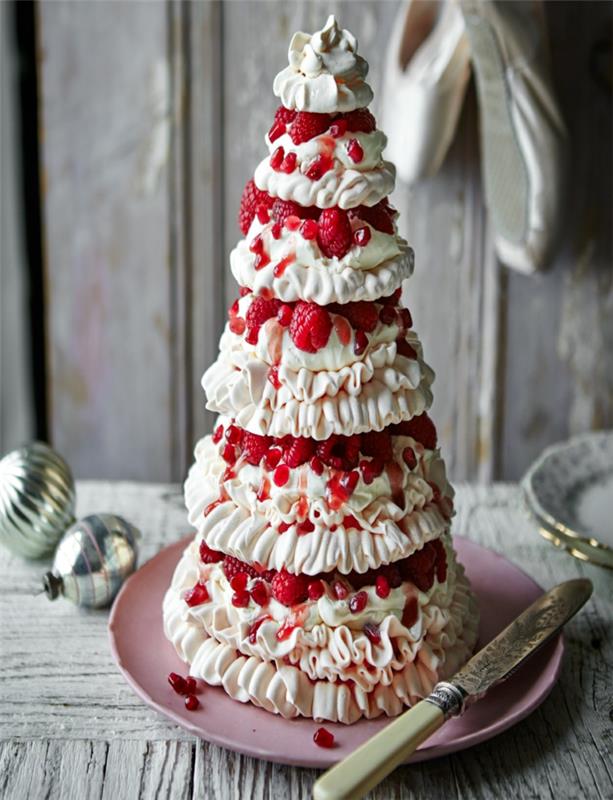 gražus baltos grietinėlės ir raudonų vaisių bokštas, rožinė lėkštė, kalėdiniai žaislai