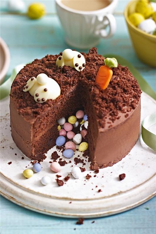 čokoladna pinata torta, okrašena za veliko noč z dvemi zajčki v marcipanu z glavami, namočenimi v torto
