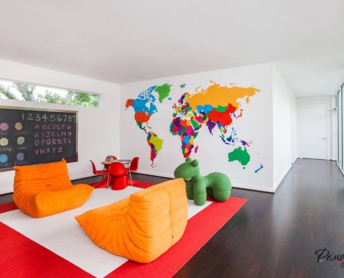 Dos sillas naranjas en la sala de juegos con un mapa en la pared.