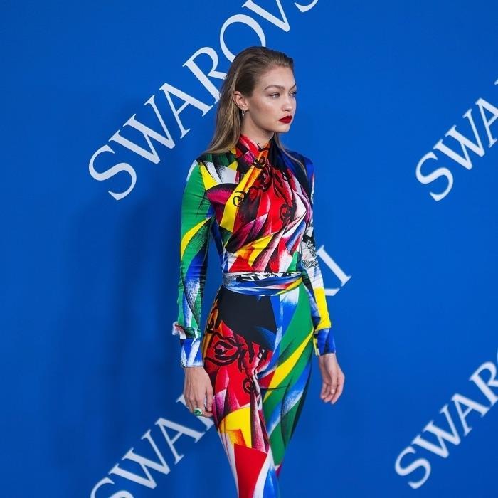 stilingas įvairiaspalvis kombinezono modelis su abstrakčiais ir geometriniais raštais, Gigi Hadid su raudonų lūpų makiažu