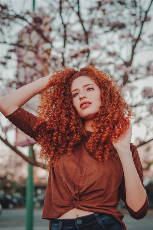 Keistai raudoni plaukai, ilgų kvadratinių šukuosenų idėja ant garbanotų plaukų, modernios moters šukuosenos tendencija 2020 m
