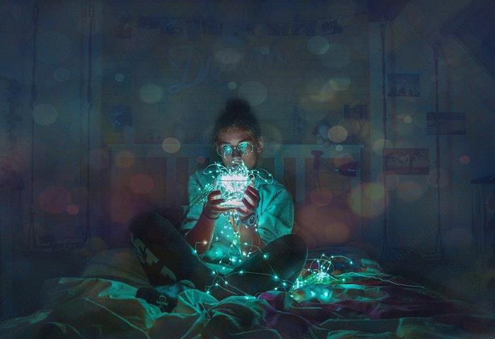 bir yatakta oturan kız, elinde peri ışıkları, siyah beyaz tumblr
