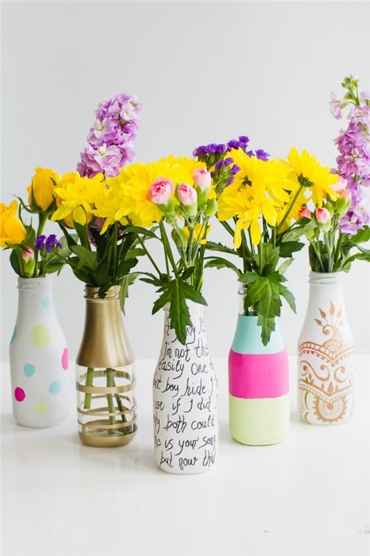 steklenice, pobarvane v različnih barvah, osrednji del kuhinjske mize, belo ozadje, cvetlični šopki
