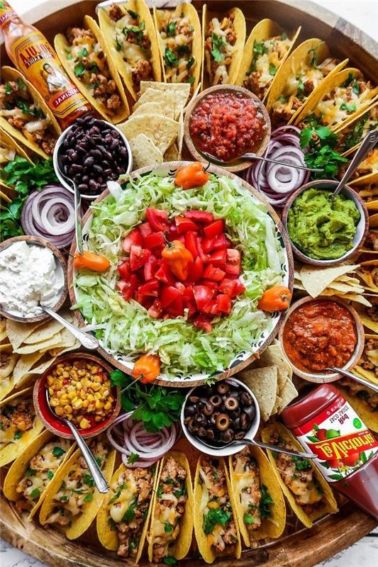 maltos jautienos taco receptas, stikliniai dubenėliai, užpildyti įvairiais ingredientais, mini tako, išdėstyti ant didelio, medinio padėklo