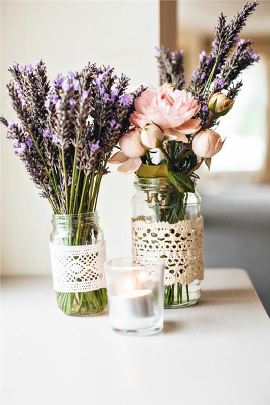 dva steklena kozarca, šopek sivke, cvetje in šopek sivke, dekor kuhinjske mize, lesena miza