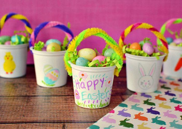 suni çim, plastik yumurta ve boru temizleyici kulplu bir çocuk odası Paskalya sepetine dönüştürülmüş plastik bardak