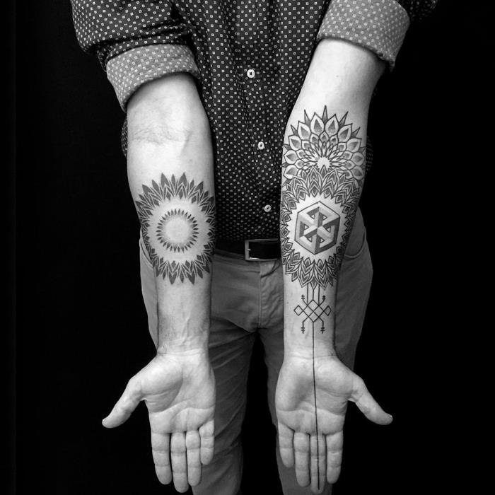 Stilizuotas mandalos piešinys ir Esherio optinė iliuzija, geometrinė tatuiruotė ant dilbio, grafinio stiliaus vyro tatuiruotės idėja, vyras, dėvintis taškuotus marškinius, smėlio spalvos kelnes ir diržą