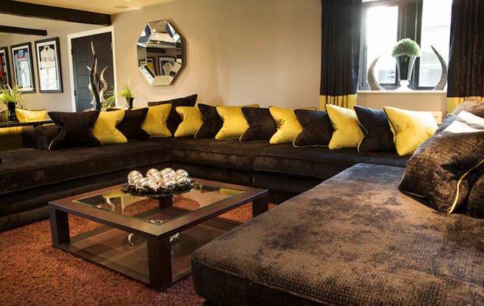 šokolado rudos kaštonų rudos sofos ir geltonos pagalvėlės