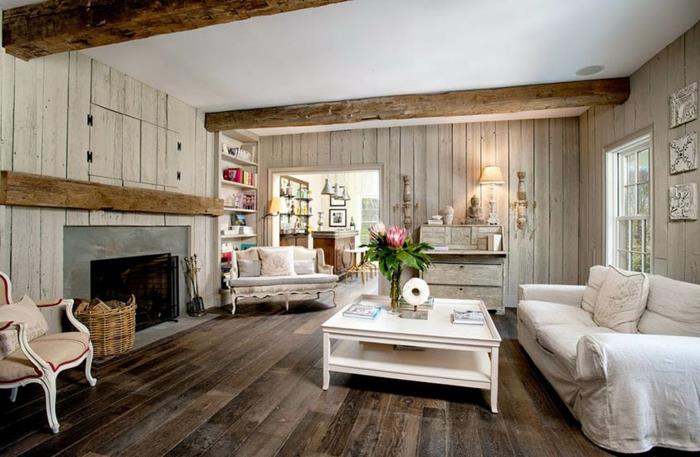 lesena tla, bela miza za dnevno sobo, starinski stol z laneno blazino, kamin in lesene stenske obloge