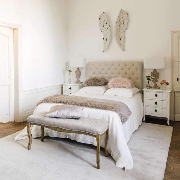 bej düğmeli yatak başlığı ve geniş açık gri halı ile yetişkin yatak odasında beyaz duvar resmi