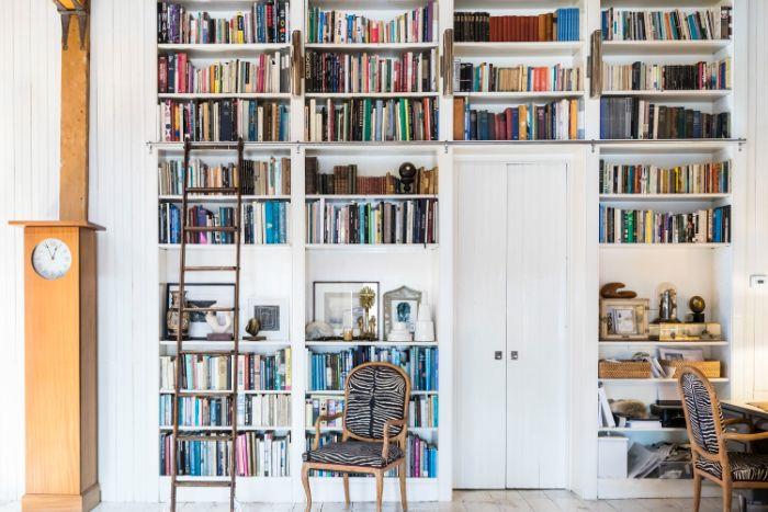 bir kapı etrafında beyaz bir duvarda büyük kitaplık İskandinav beyaz kitaplık fikri
