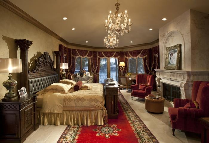 spalnica v ciganskem slogu, bež postelja, razkošni stropi, kamin, oranžni naslanjači, usnjeno vzglavje