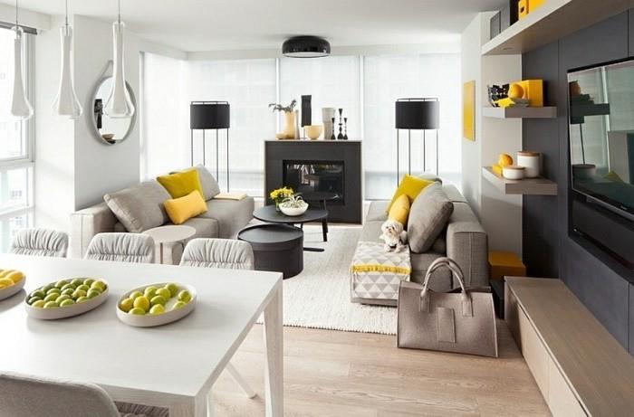 pilkos sofos, juodo metalo žurnaliniai staliukai, pilka ir balta svetainė, geltonos pagalvės, medinės grindys