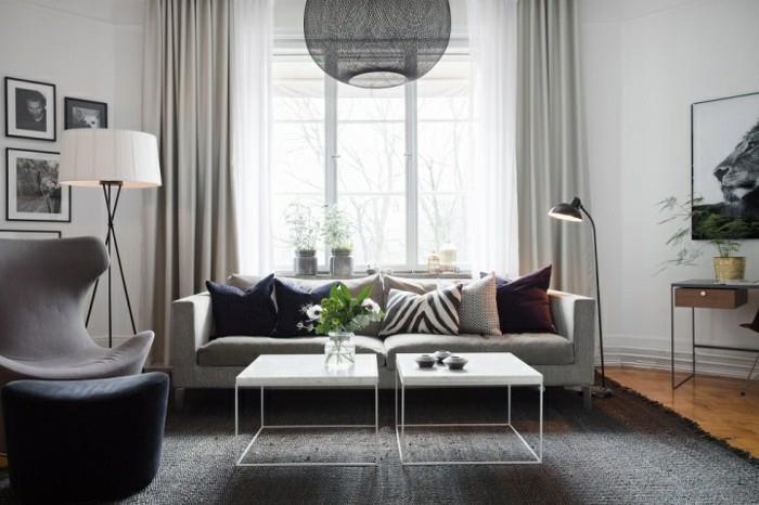 pilkas kilimas, pilka sofa ir fotelis, pilka ir balta svetainė, balti metaliniai žurnaliniai staliukai