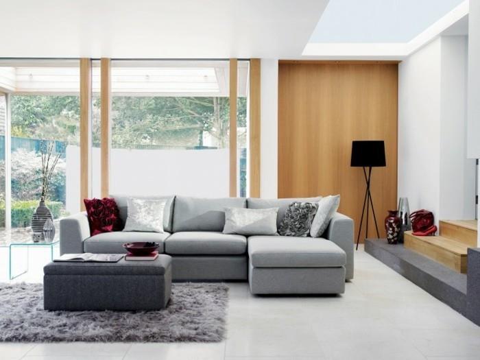 pilka kailinė antklodė, pilka kampinė sofa, baltos plytelių grindys, pilkos svetainės sienos, pilka pufinė