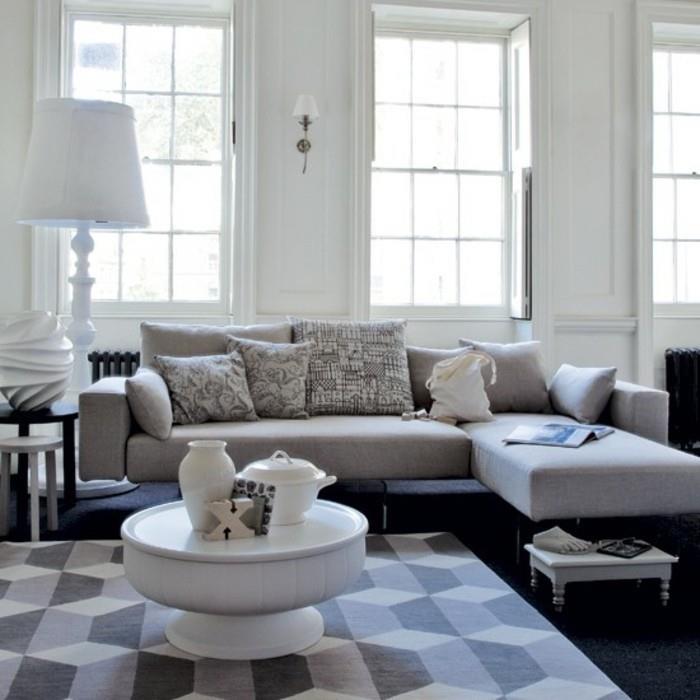 pilkas ir baltas geometrinis kilimas, pilkos spalvų schemos, pilka kampinė sofa, spausdintos pagalvės, baltas kavos staliukas
