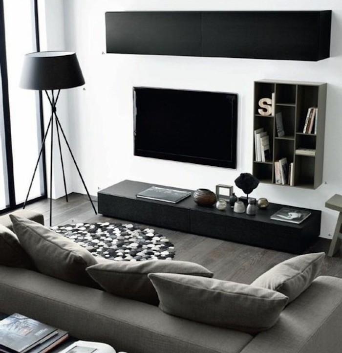 juodos spintelės, pilka sofa, medinės grindys, pilkos svetainės sienos, kilimėlis iš pom pomų