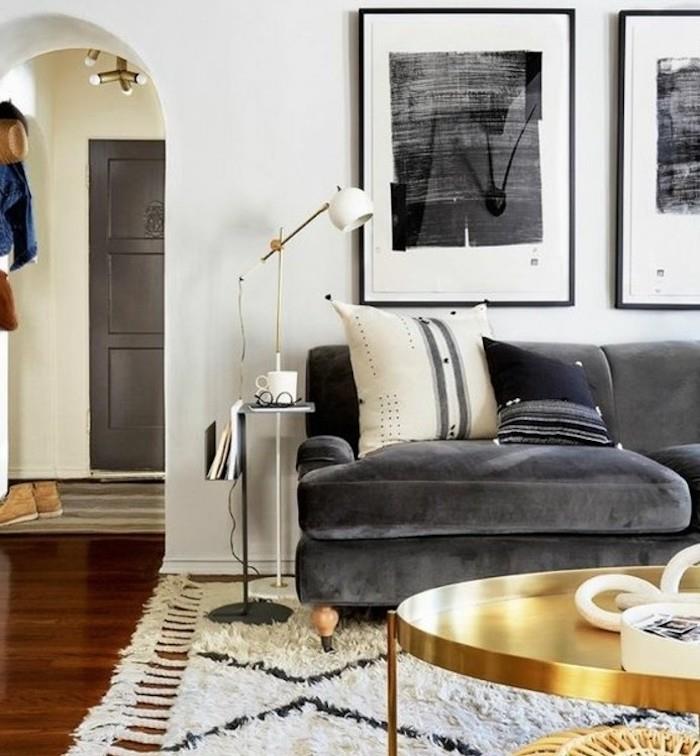 gražios svetainės, pilka aksominė sofa, žalvarinis kavos staliukas, baltos sienos, medinės grindys, baltas kilimas