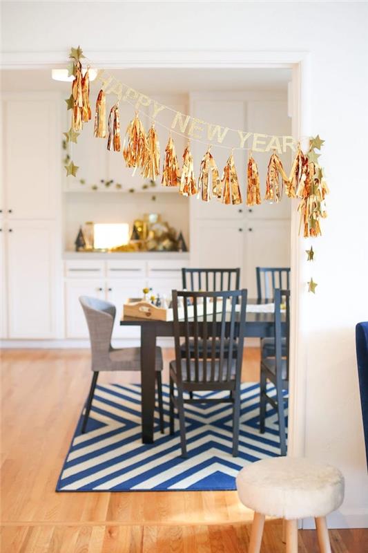 Altın saçaklı ve Yeni Yılınız Kutlu Olsun mesajı ile bir ponpon çelenk içinde Yılbaşı için yemek odası dekoru