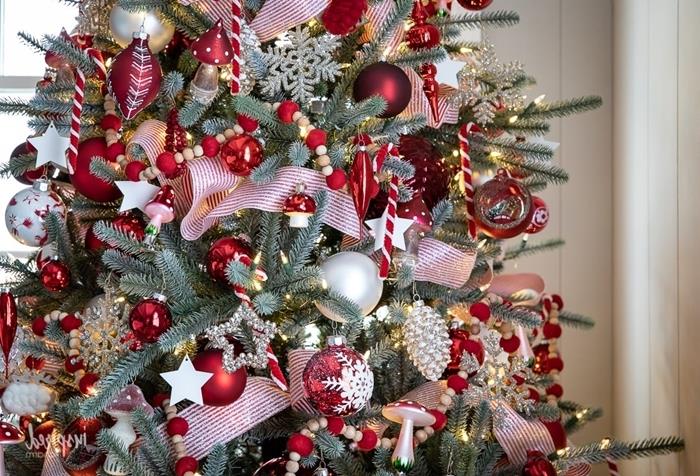 medžio ir raudonų karoliukų girlianda raudona ir balta Kalėdų eglutė raudona juostelė kankorėžių rutuliai papuošalai