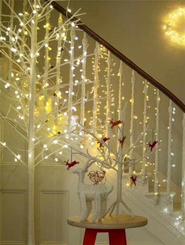 šviesios girliandos-Kalėdos-girlianda-šiuolaikinio namo koridoriuje-balti-mediniai laiptai