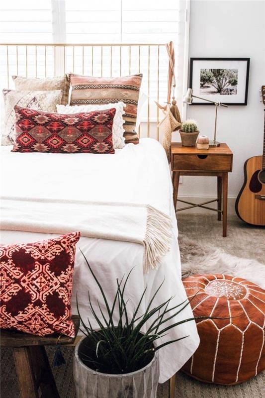 hipi elegantna in boemska postavitev spalnice z lesenim pohištvom in dekorativnimi dodatki z etničnimi motivi