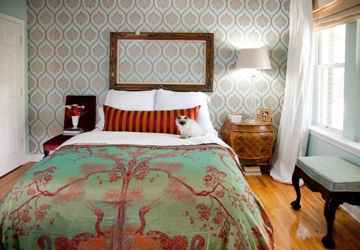 deco prazen starinski leseni okvir, velikega formata, prevleka za posteljnino chinoiserie, belo posteljno perilo, blazina v rdeči in oranžni barvi, cvetlične tapete, parket iz svetlega lesa, retro nočna omarica